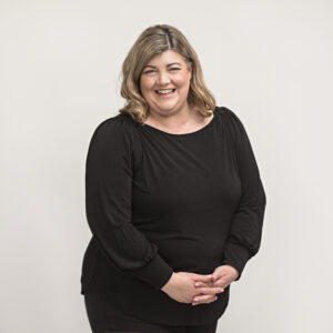 Emma smiling at camera, grey background