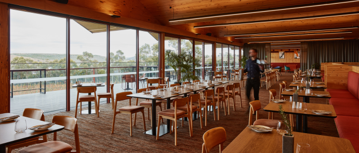 Restaurant dining area at Iron Creek Bay Estate with tables set and large windows overlooking the landscape.