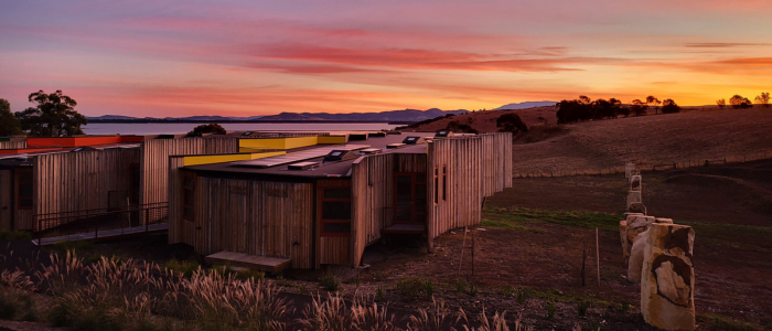 Modern cabins at Iron Creek Bay Estate overlooking rolling hills and water at sunset