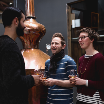 Guests enjoy a guided cider tasting beside a copper still at Willie Smith’s Apple Shed.