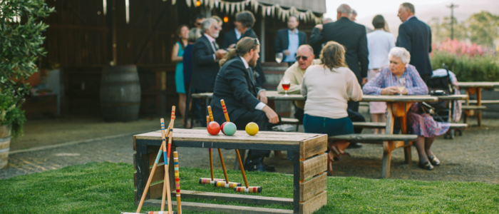 Croquet equipment sits on the lawn as guests mingle and dine outdoors during an event at Willie Smith’s Apple Shed.