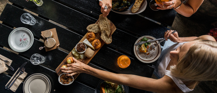 Overhead view of guests sharing a meal and drinks around a table at Willie Smith’s Apple Shed.